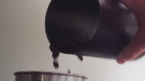 coffee beans falling into a grinder