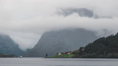 Wunderschöner-Zeitraffer-Bei-Norwegen-Sæbø,-Wolken-Ziehen-An-Bergen-Vorbei,-Mit-Einem-Malerischen-Blick-Auf-Das-Meer-Im-Vordergrund,-Kleines-Boot,-Das-Durch-Den-Rahmen-Fährt-Und-Langsam-Herauszoomt