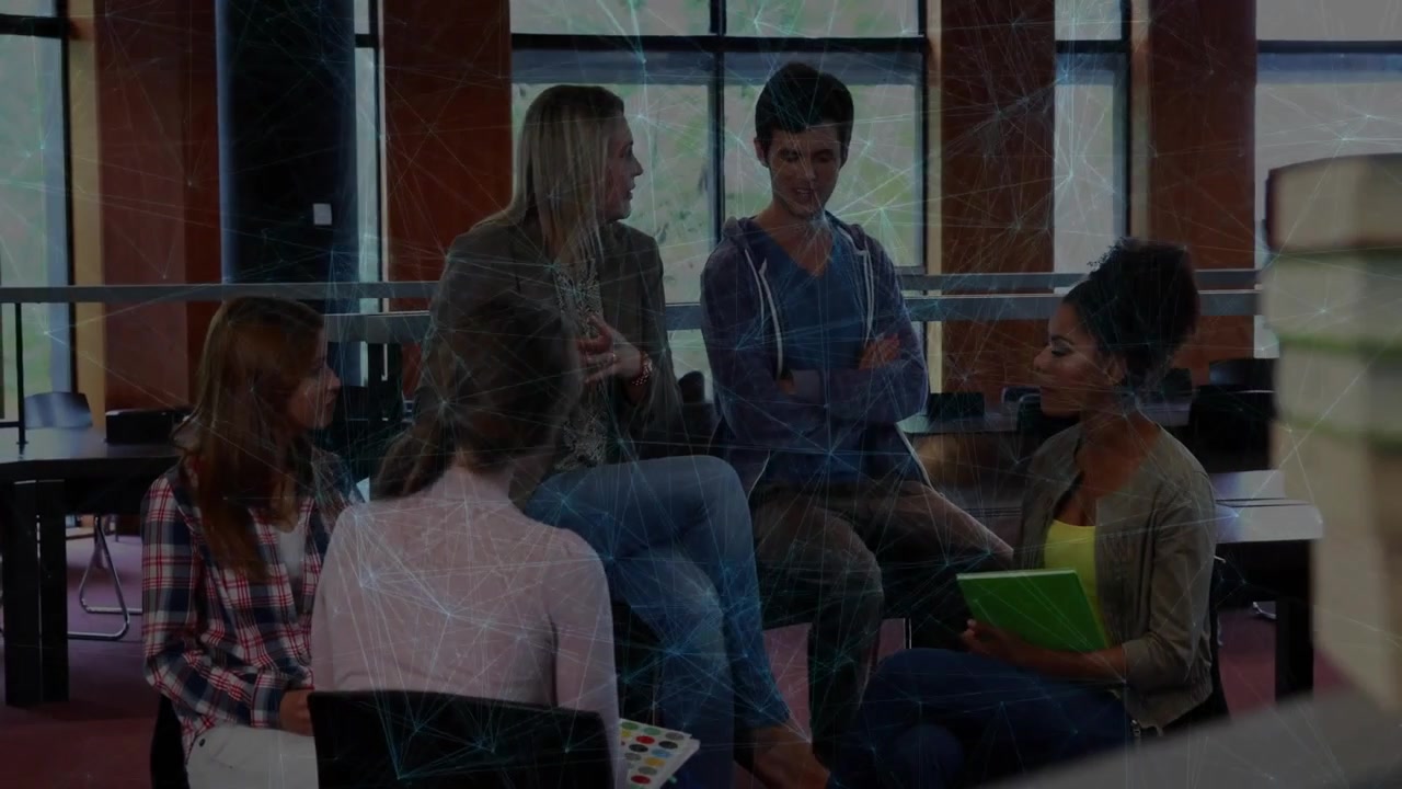 blonde speaker gesturing in work meeting, arriving newcomer jotting notes on green notebook