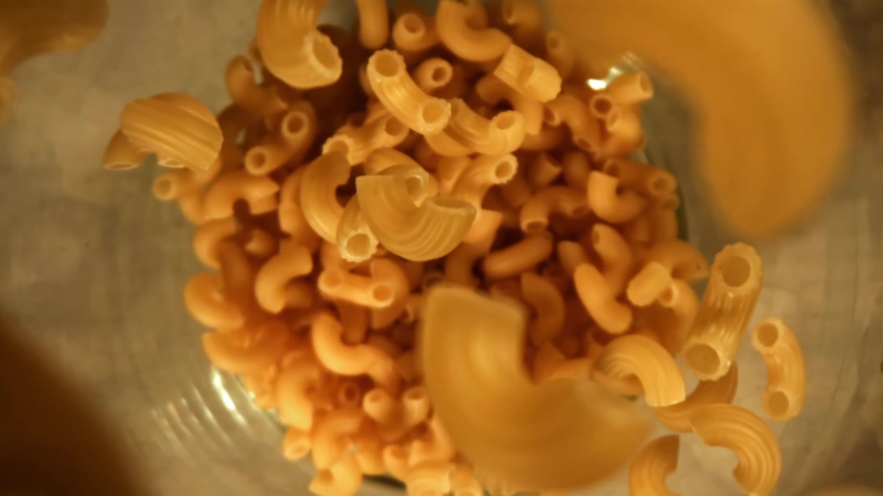 Pasta maccheroni cruda che cade al rallentatore