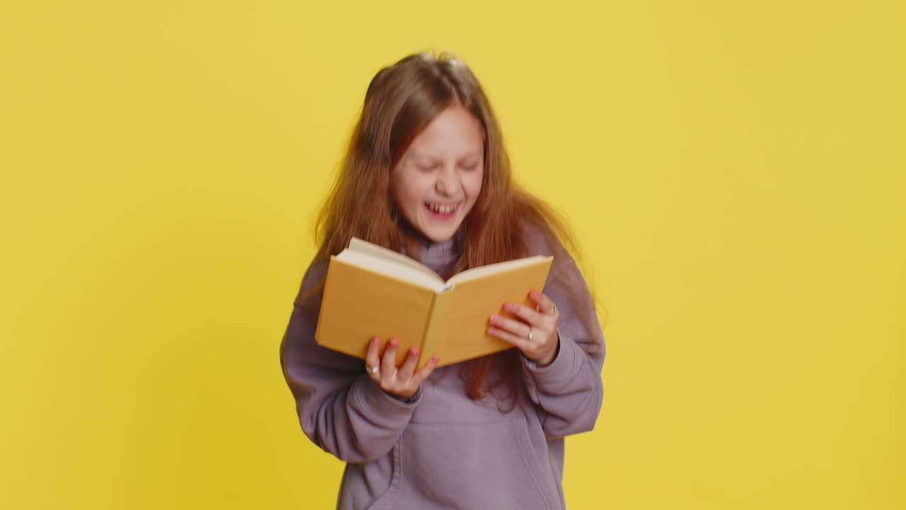 Happy child girl kid reading funny interesting fairytale story book leisure hobby learning study