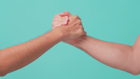 close up shot of arm wresting of two men in isolate green screen in background. the strong man win the competition at in end. man power between competitor and rival in business concept.