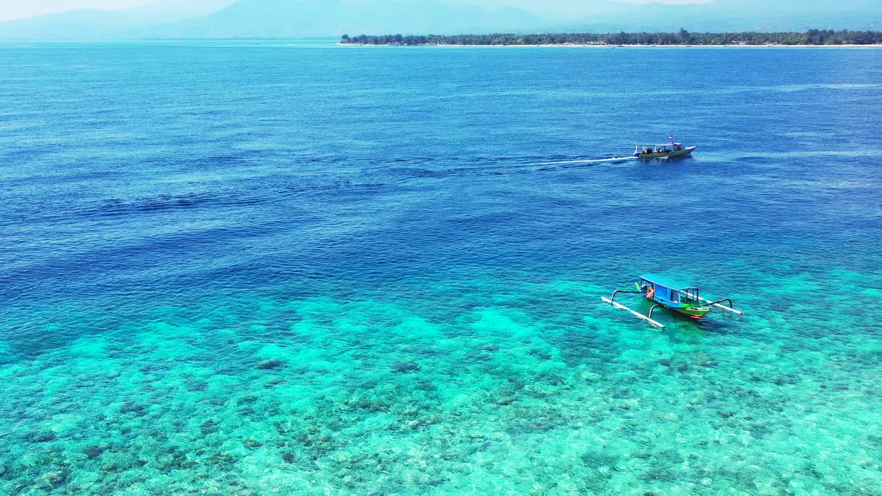 Boats sailing around shore of tropical island on shallow lagoon with blue turquoise clean water on a sunny vacation summer day in Philippines