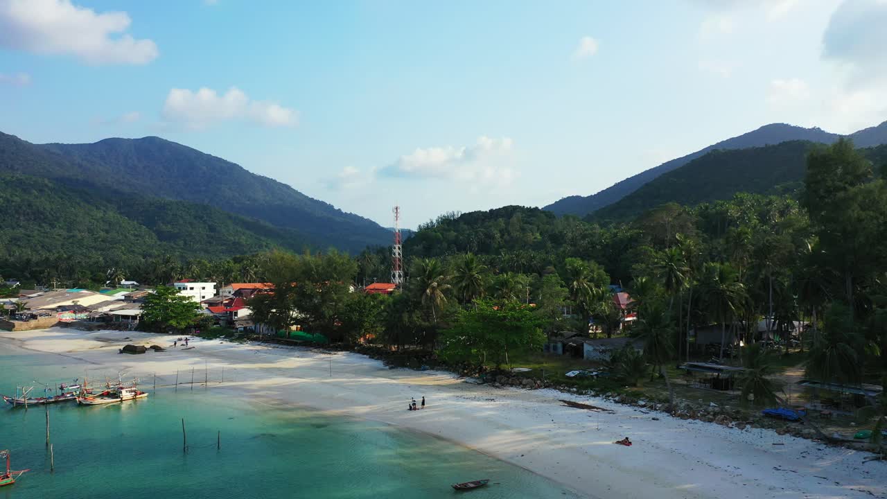 Bosque de palmeras verdes, complejos turísticos de lujo y playa de arena en una isla tropical, laguna tranquila de color turquesa con barcos flotando