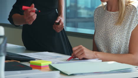 Close-Up-Of-Two-Businesswomen-At-Desk-Discussing-Document