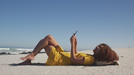 Afroamerikanische-Frau-Ihr-Telefon-Am-Strand