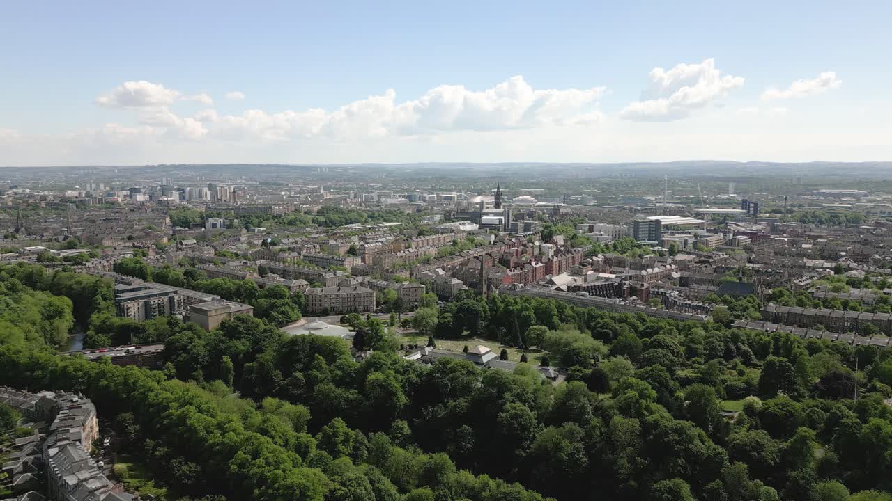 Aerial fly over Glasgow Botanic Gardens with Kibble Palace forested zones and West End of Glasgow in background, Glasgow, Scotland, UK