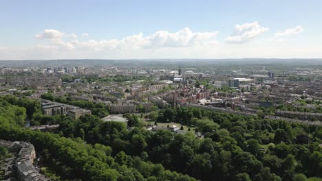 aerial fly over glasgow botanic gardens with kibble palace forested zones and west end of glasgow in background, glasgow, scotland, uk