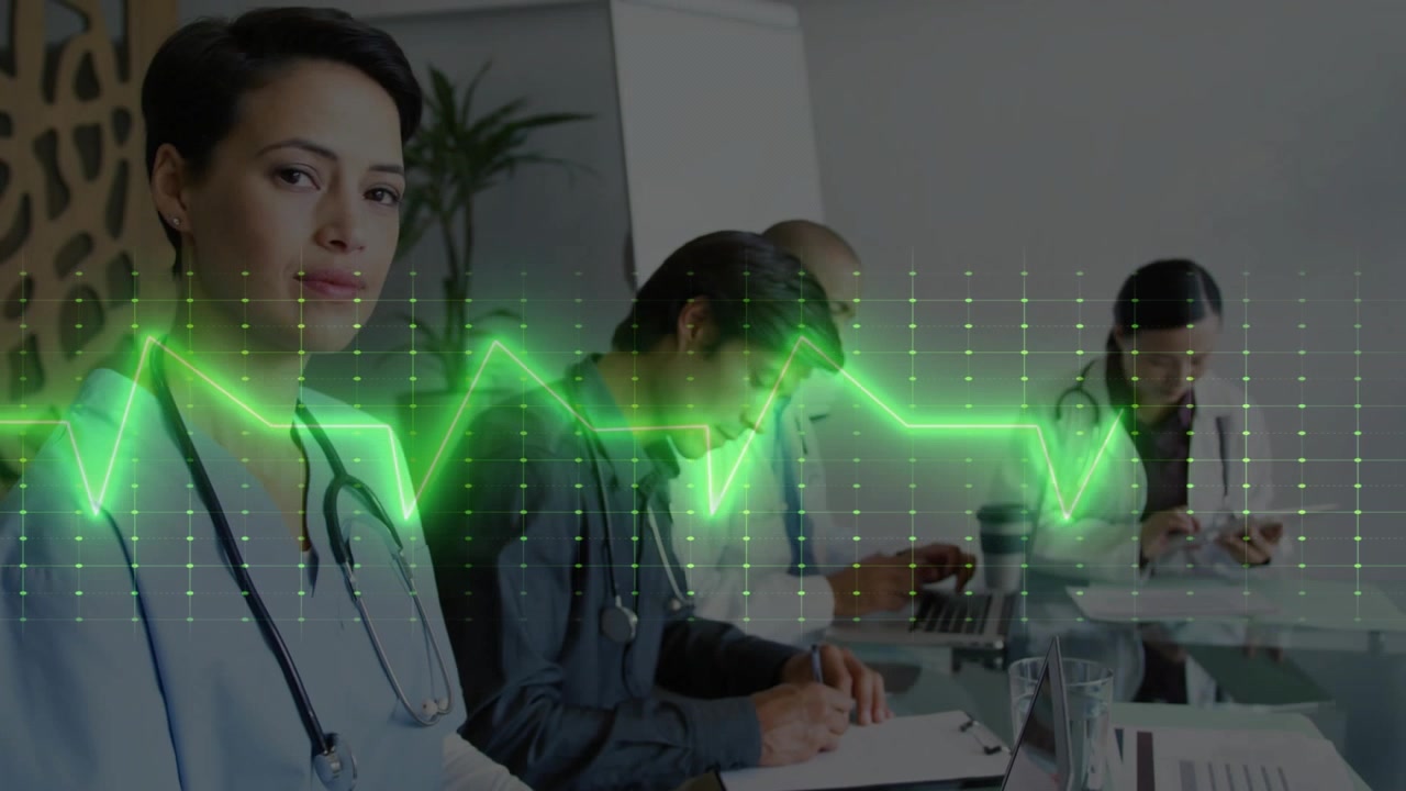 Medico a sinistra che digita mentre il team prende appunti, una forma d'onda apparendo e scorrendo attraverso il team, mostrando i parametri vitali.
