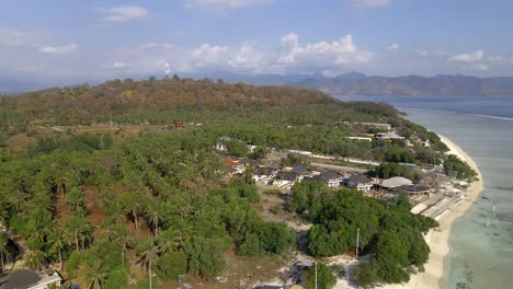 Amplia-Toma-Aérea-De-Colinas-Verdes-En-La-Isla-De-Gili-Trawangan-Con-Playa-Y-Océano-Durante-La-Luz-Del-Sol