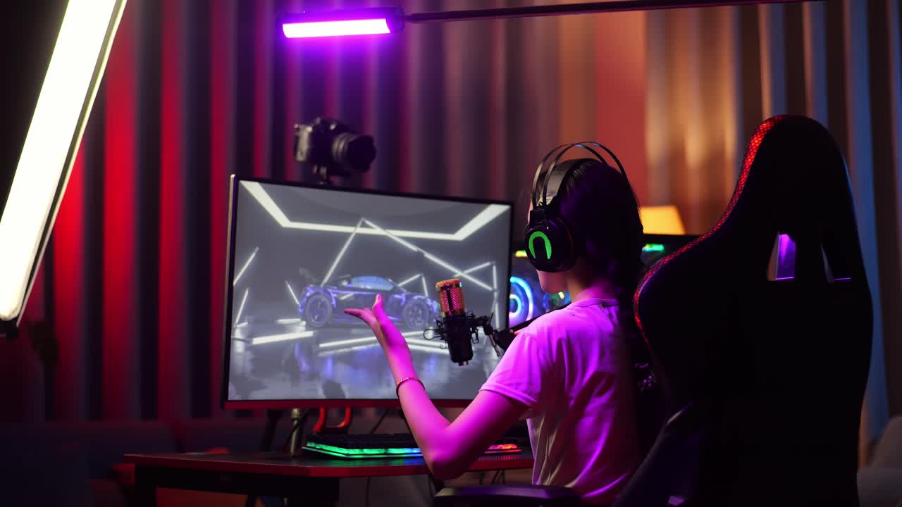 Back View Of Asian Girl Streamer Playing Car Racing Game Over Network On Personal Computer. Challenge And Bully Competitor, Live Stream Video Game, Desk Illuminated By Rgb Led Strip Light