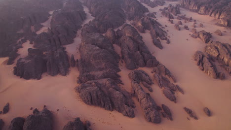 sandstone rock formations and dunes at sunrise in tassili n’ajjer national park