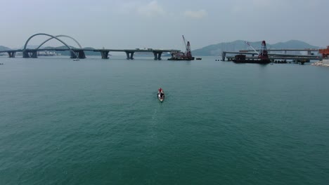 dragon boat team rowing to the pace of an onboard drummer, aerial view