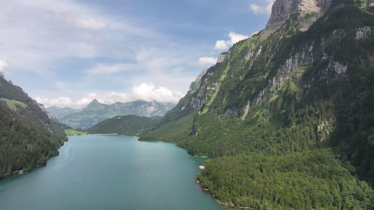 Veduta aerea che si allontana per rivelare il Lago Klöntalersee nella regione di Glarus Süd del Cantone di Glarona, Svizzera.