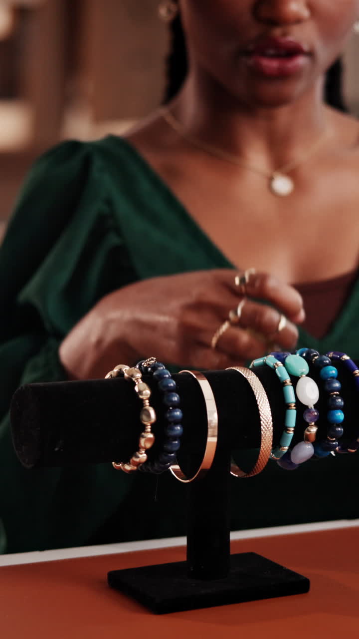 Primo piano di una donna che sceglie braccialetti colorati da un espositore