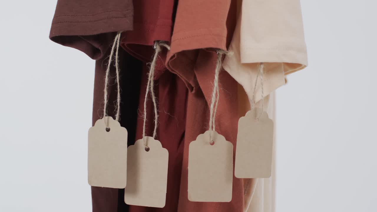 ⁇ 색 배경에 태그와 복사 공간을 가진 네 개의 t 셔츠의 비디오