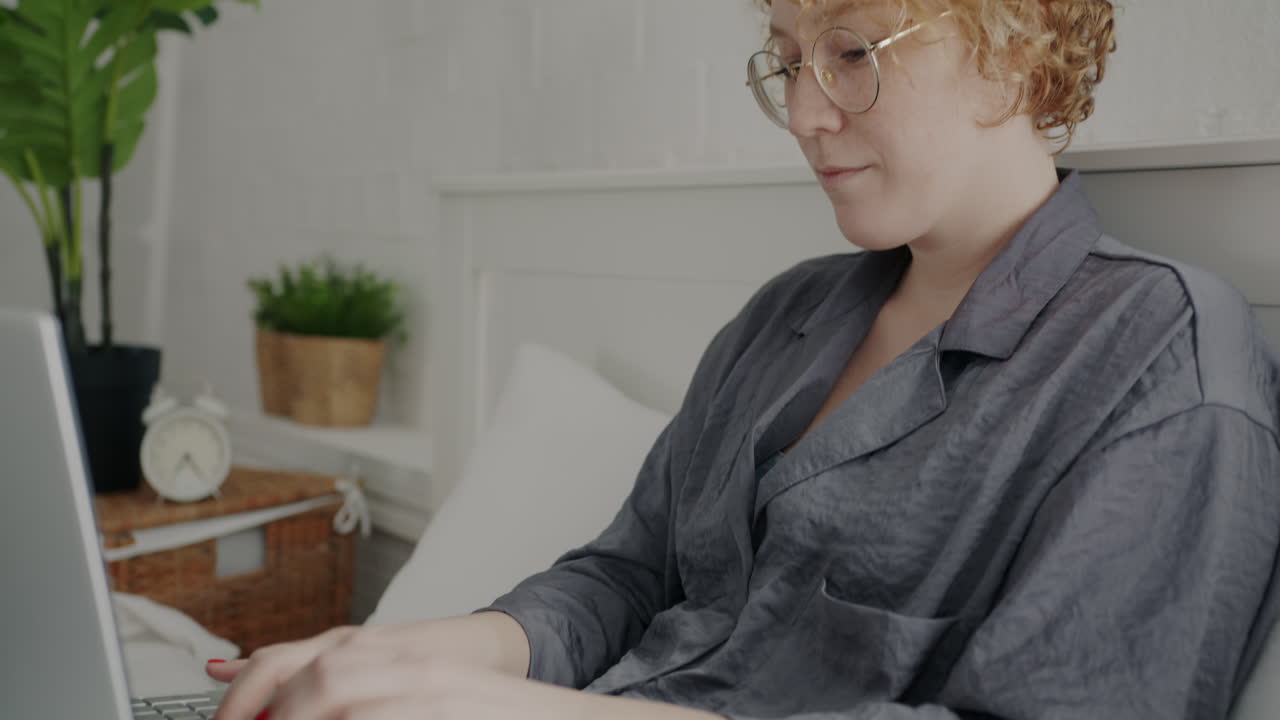 Woman working on laptop in bed