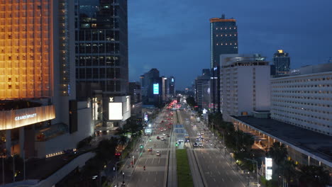 Aerial-shot-flying-past-Selamat-Datang-Monument-in-Jakarta-towards-multi-lane-highway-through-city-center