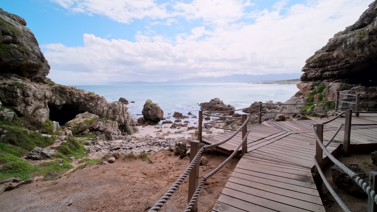 Wooden boardwalk at historic Klipgat Cave with Atlantic ocean views, Walker Bay