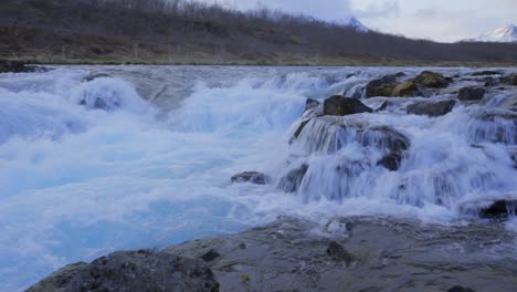 panning shot of strong splashing icelandic hlauptungufoss waterfall over mossy rocks