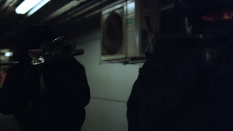 Anti-terrorist-squad-with-rifles-walking-in-corridor.-SWAT-members-using-shield