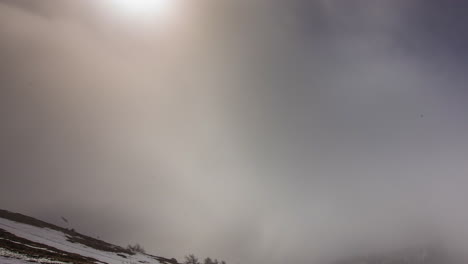 Thick,-dense-fog-fills-the-valley-below-the-mountain-peaks---time-lapse