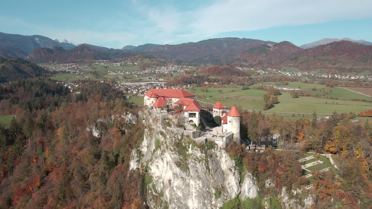 The castle situated on a rock in the alpine region of Slovenia with the Alps in the background with a stunning aerial view of the grad