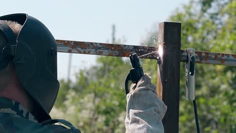 Handwerker-Schweißt-Zaunmetallteile-In-Zeitlupe-Von-Hinten