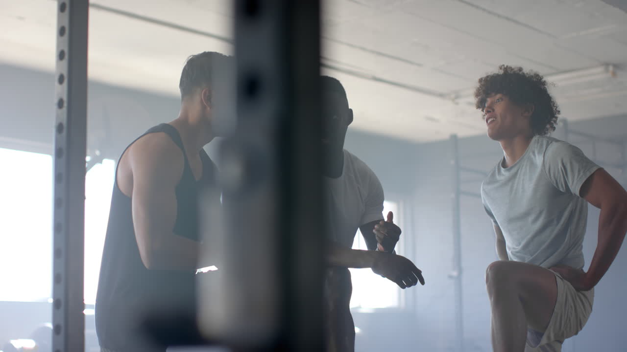 Exercising in gym, men doing high knees and motivating each other