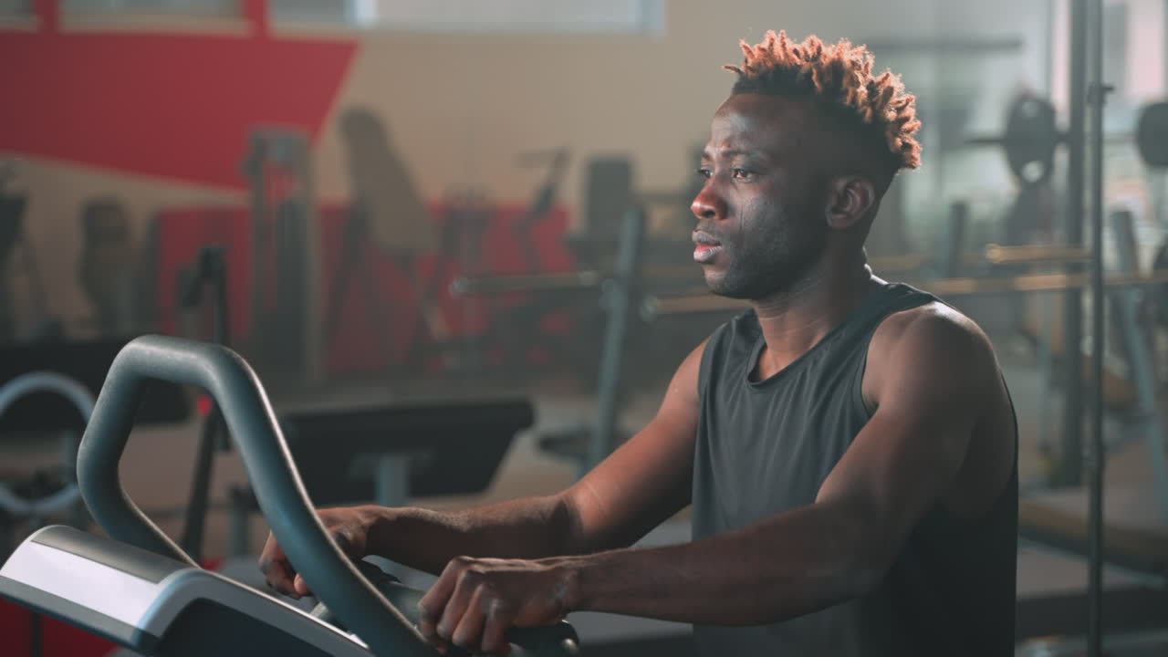 Man Exercising on an Exercise Bike in a Gym