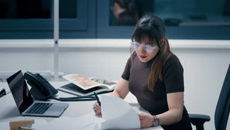 Vista-Lateral-De-Una-Hermosa-Joven-Que-Trabaja-En-Papeles-En-La-Oficina-Harta,-Agotada-Y-Estresada-Del-Trabajo