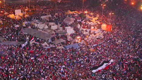 overhead view as protestors jam tahrir square in cairo egypt at a large nighttime rally