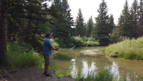 male fishing in river with scenic canadian landscape, surrounded by pine trees