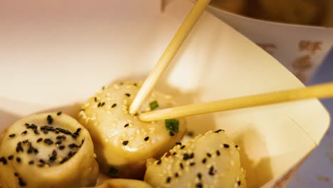 chopsticks picking up delicious pan-fried buns