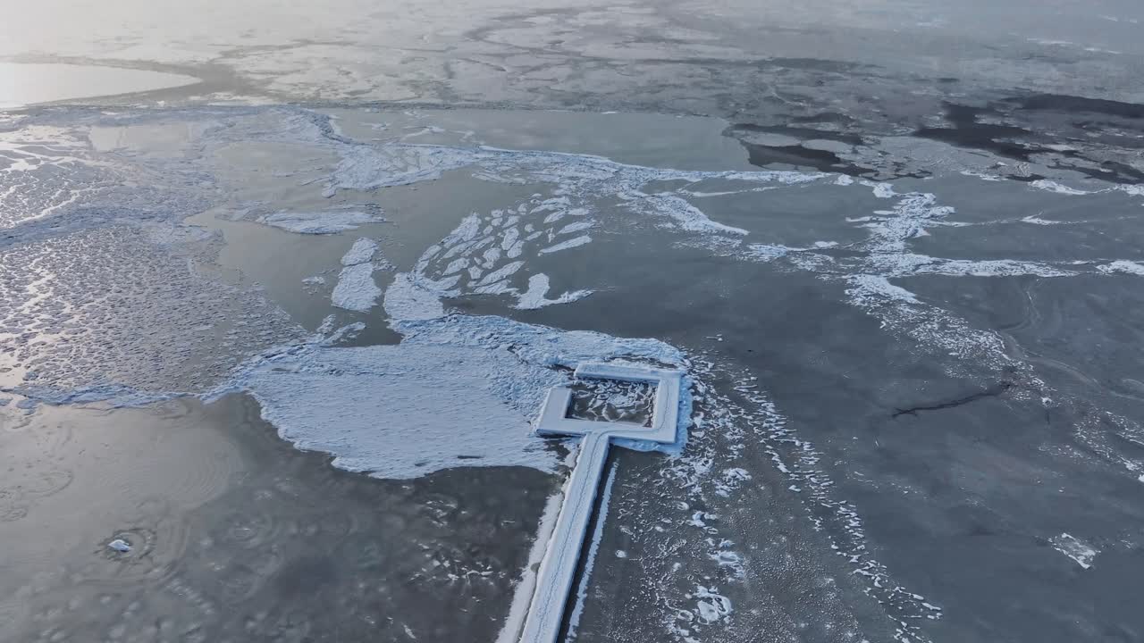 Panoramic view of the snowy and frozen pier leading to the Curonian lagoon, which is frozen in winter time