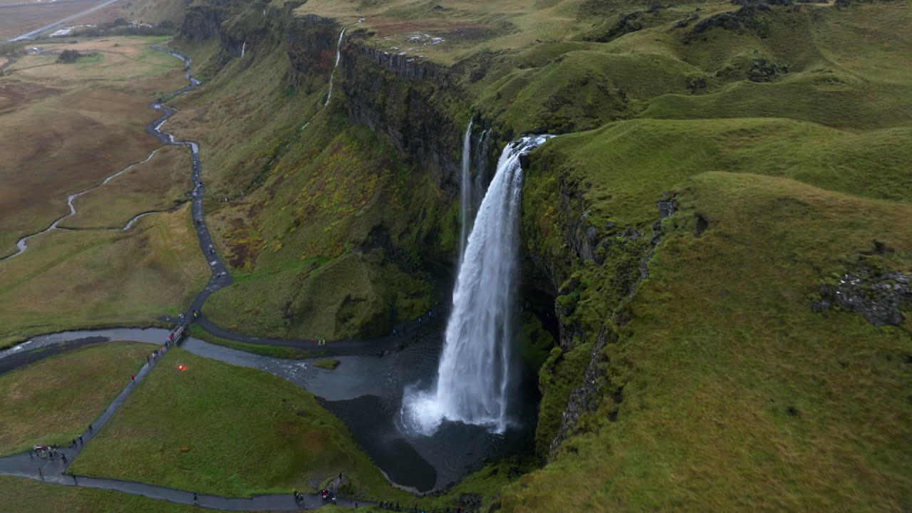 los turistas visitan la majestuosa cascada de seljalandsfoss en islandia