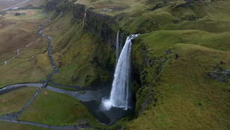 los turistas visitan la majestuosa cascada de seljalandsfoss en islandia