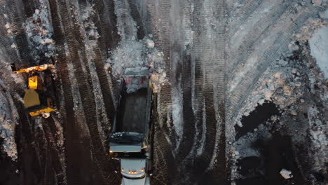 aerial directly above of heavy machinery on snow cleaning works aftermath winter snowstorm