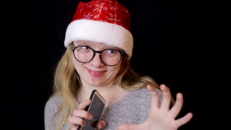teenage blonde girl taking selfie with smartphone in her pink room shot of young teenage blonde girl in pink outfit taking selfie with smartphone while sitting on bed in her room