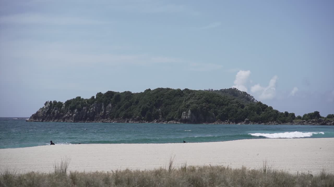 Coastal landscape with island, beach, and person