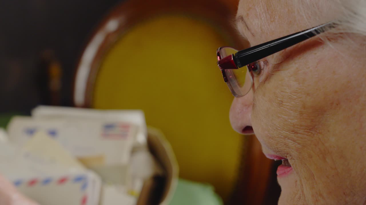 Elderly Mum reads aloud old sentimental family air mail letters CLOSE-UP