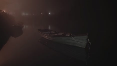 green fishing boat moored by slip way night dense fog