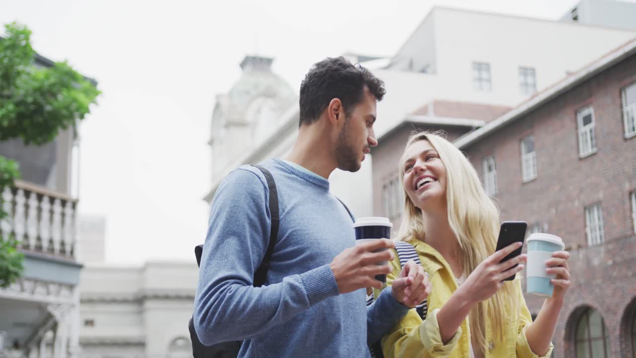 Vista laterale di coppia caucasica in movimento che tiene un caffè da asporto
