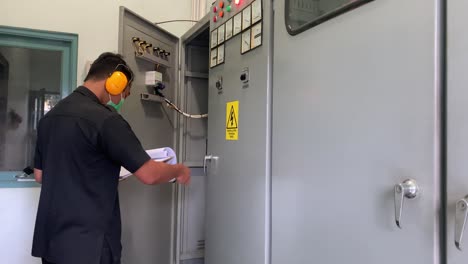 an electrician is controlling the installation in the generator room