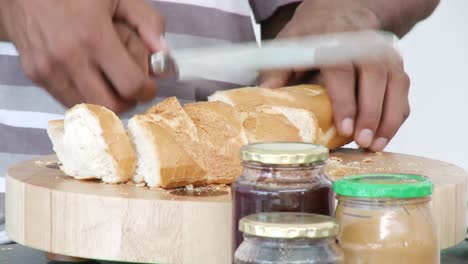 Close-up-of-people-cutting-bread-in-the-kitchen