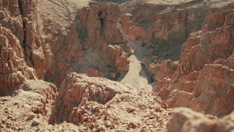 Rock-rolls-over-dry-rocky-terrain-of-Judean-desert,-Israel