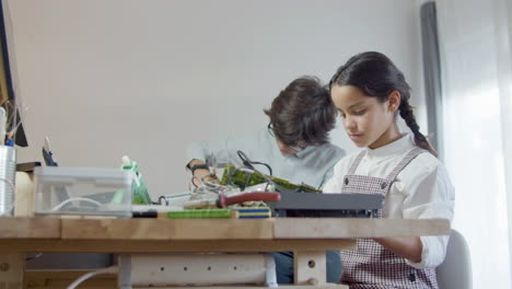 girl welding and boy using screwdriver for educational project