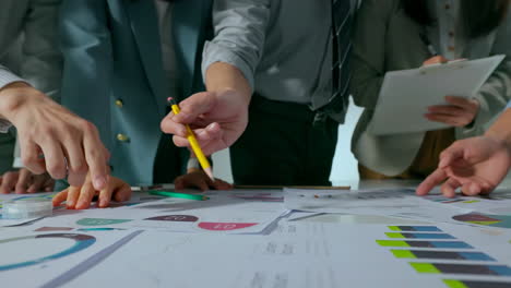 Close up Business team sharing his business ideas with colleagues during meeting in modern friendly workplace office, data analysis with laptop and paperwork, hands with pencil review market research.
