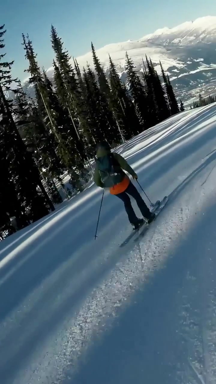 Video verticale: Rider con giacca rossa scende intagliando una pista battuta con la tavola per divertimento, spazio per il testo