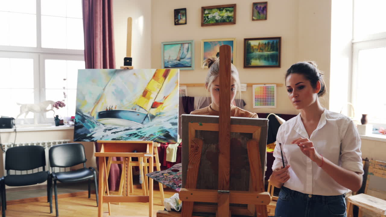 두 명의 여성이 미술 스튜디오에서 그림을 그리고 있습니다.
